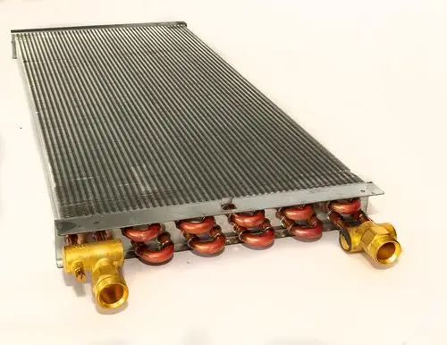 Wärmetauscher mit Metalloberfläche und mehreren Kupferrohren, geeignet für Daikin HP Convector, mit zwei sichtbaren Anschlussöffnungen.